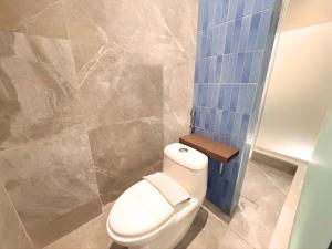 a bathroom with a toilet and a blue tile wall at The W Avenue in Bandung