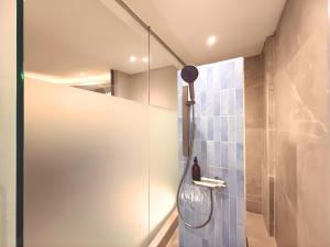 a shower with a glass door in a bathroom at The W Avenue in Bandung +27 photos