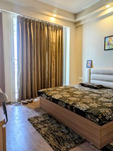a bedroom with a bed in front of a window at Comfort Corner in Greater Noida
