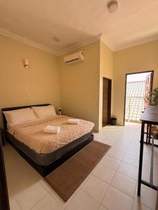 a bedroom with a bed with two towels on it at Summer village in Kampong Pasir Hantu