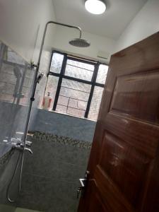 a bathroom with a shower and a door and a window at Bay Loft 1 Br Netflix Lake Views, Starlink in Homa Bay +23 photos