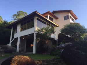 Cette grande maison blanche possède de nombreuses fenêtres. dans l'établissement Sunset Cacupé, à Florianópolis