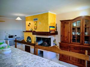 a living room with a fireplace in a kitchen at Monti e Mare in Lanusei