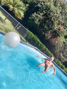 a man in a swimming pool with a ball in the water at RosePlace Valsequillo in Durazno +11 photos