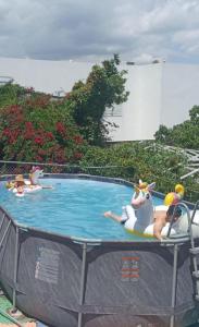 a group of people riding on a ride in a pool at RosePlace Valsequillo in Durazno
