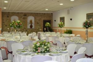 a banquet hall with white tables and white chairs at Rincón del Abade in Encinasola