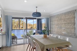 a dining room with a table and chairs and a window at River Retreat in Dora Creek