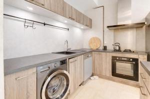 a kitchen with a washing machine and a sink at La Lanterne Plage in Nice