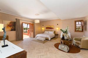 La Palmeraie De L'Atlas في مراكش: غرفة نوم مع سرير وغرفة معيشة