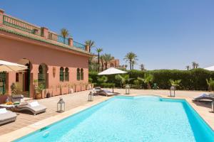 a villa with a swimming pool and a patio at La Palmeraie De L'Atlas in Marrakech