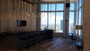 a bar with stools in a room with large windows at Downtown Miami Deluxe Apartment in Miami