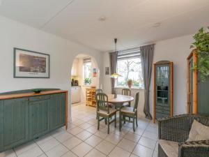 a kitchen and dining room with a table and chairs at Holiday Home near Dutch Beach with Pool in Sint Maartensvlotbrug
