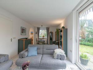 a living room with a couch and a table at Holiday Home near Dutch Beach with Pool in Sint Maartensvlotbrug