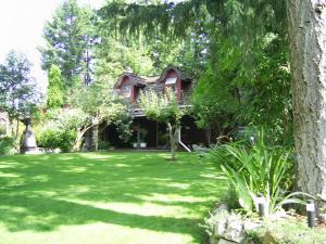 a house in the middle of a green yard at Garden House in Courtenay