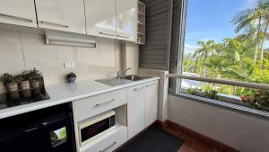 a kitchen with a sink and a large window at Bella Vista Coral Sea Views in Port Douglas