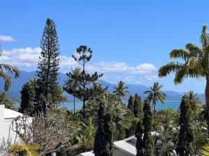 a view of the ocean from a resort with palm trees at Bella Vista Coral Sea Views in Port Douglas