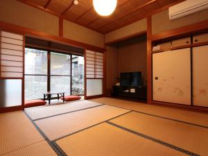an empty room with a table and a window at 港の魚宿 おおそね in Owase +27 photos