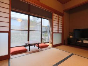 a living room with a table and a large window at 港の魚宿 おおそね in Owase