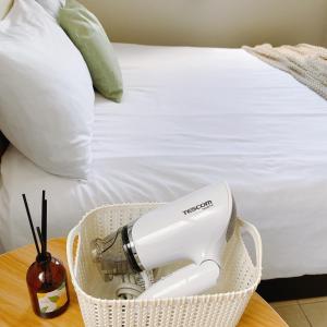a hair dryer in a basket on a table next to a bed at 綠島夏御 微熱海岸 Coast Venus in Green Island