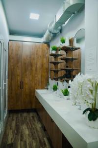 a bathroom with wooden cabinets and white counter tops at Aiva Hostel in Bishkek