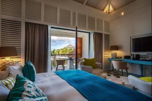 a bedroom with a large bed and a living room at Le Barthélemy Hotel & Spa in Gustavia