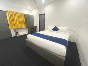 a bedroom with a large bed with a yellow curtain at Hotel unity Park in Pondicherry