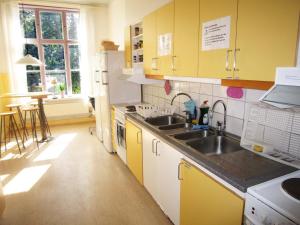 una cocina con armarios amarillos y fregadero en Karlsborgs vandrarhem och B&B, en Karlsborg