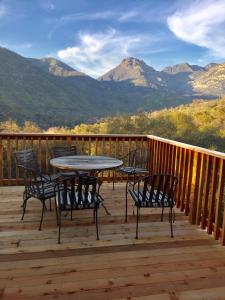 a table and chairs on a deck with mountains at Alta Peak Vista in Three Rivers