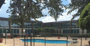 un bâtiment avec une piscine devant dans l'établissement The Biltmore Hotel Oklahoma, à Oklahoma City