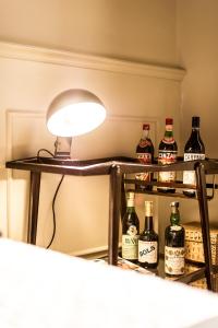 een lamp op een plank met flessen alcohol bij Arnobio Florence Suites in Florence