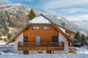 een blokhut met een balkon in de sneeuw bij Eschenweg in Bad Kleinkirchheim