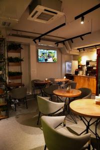 a restaurant with tables and chairs in a room at Aiva Hostel in Bishkek