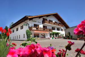 a large white building with flowers in front of it at Gasthof Anich in Natz-Schabs