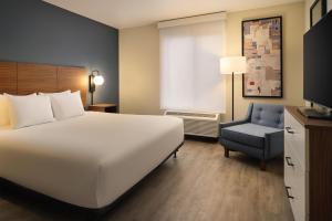 a hotel room with a large bed and a chair at Hyatt Studios Kalispell in Kalispell