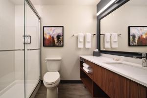 a bathroom with a toilet and a sink and a mirror at Hyatt Studios Kalispell in Kalispell