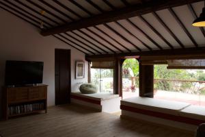 a living room with two beds and a television at Pousada Irradiante in Olinda