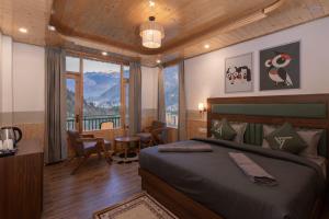 a bedroom with a bed and a desk and a window at The Trippy Tribe Manali in Manāli