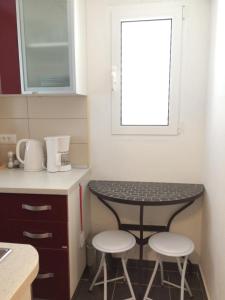 a small kitchen with a table and two stools at Villa Radoš - 4 Sterne, 4 Apartments für maximal 22 Gäste in Supetar