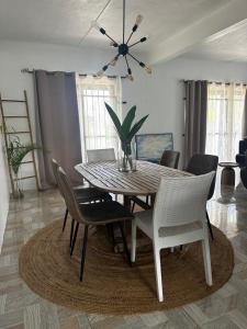 a dining room table with chairs and a vase with a plant at OC Villa in Calodyne