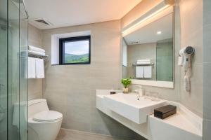 a bathroom with a sink and a toilet and a mirror at La Cactus Oceanview Resort Quy Nhon in Quy Nhon