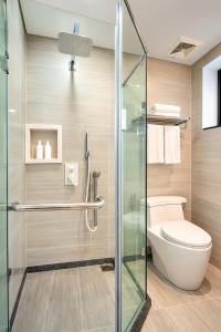 a bathroom with a toilet and a glass shower at La Cactus Oceanview Resort Quy Nhon in Quy Nhon