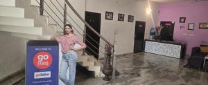 a man is standing next to a go stairs sign at Taj Guest House in Agra