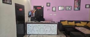 a living room with a couch and a purple wall at Taj Guest House in Agra