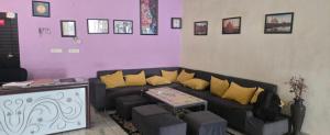 a living room with a blue couch and yellow pillows at Taj Guest House in Agra