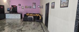 a living room with a couch and purple walls at Taj Guest House in Agra