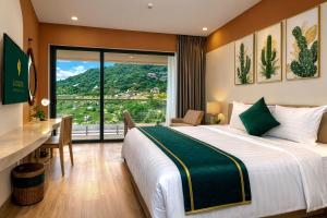 a bedroom with a bed and a desk and a window at La Cactus Oceanview Resort Quy Nhon in Quy Nhon