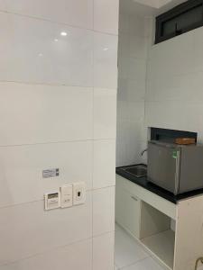 a kitchen with white walls and a counter with a microwave at LUCKY HOTEL LIEN PHUONG in Ho Chi Minh City