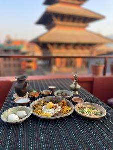 a table with plates of food on top of it at Rato Ghar Hotel and Rooftop Restaurant in Bhaktapur