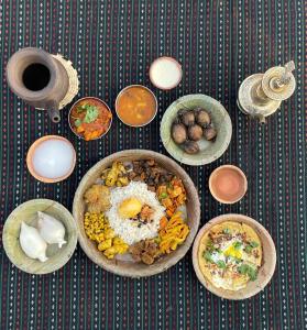 a table with many plates of food on it at Rato Ghar Hotel and Rooftop Restaurant in Bhaktapur +21 photos