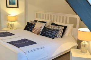 a bedroom with a white bed with pillows at The Loft at Venga in Portishead